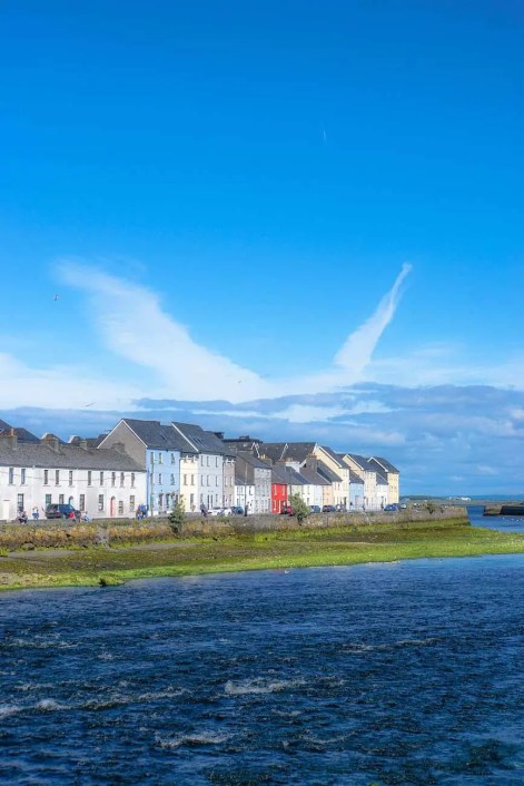 white and brown houses near green grass field under blue sky